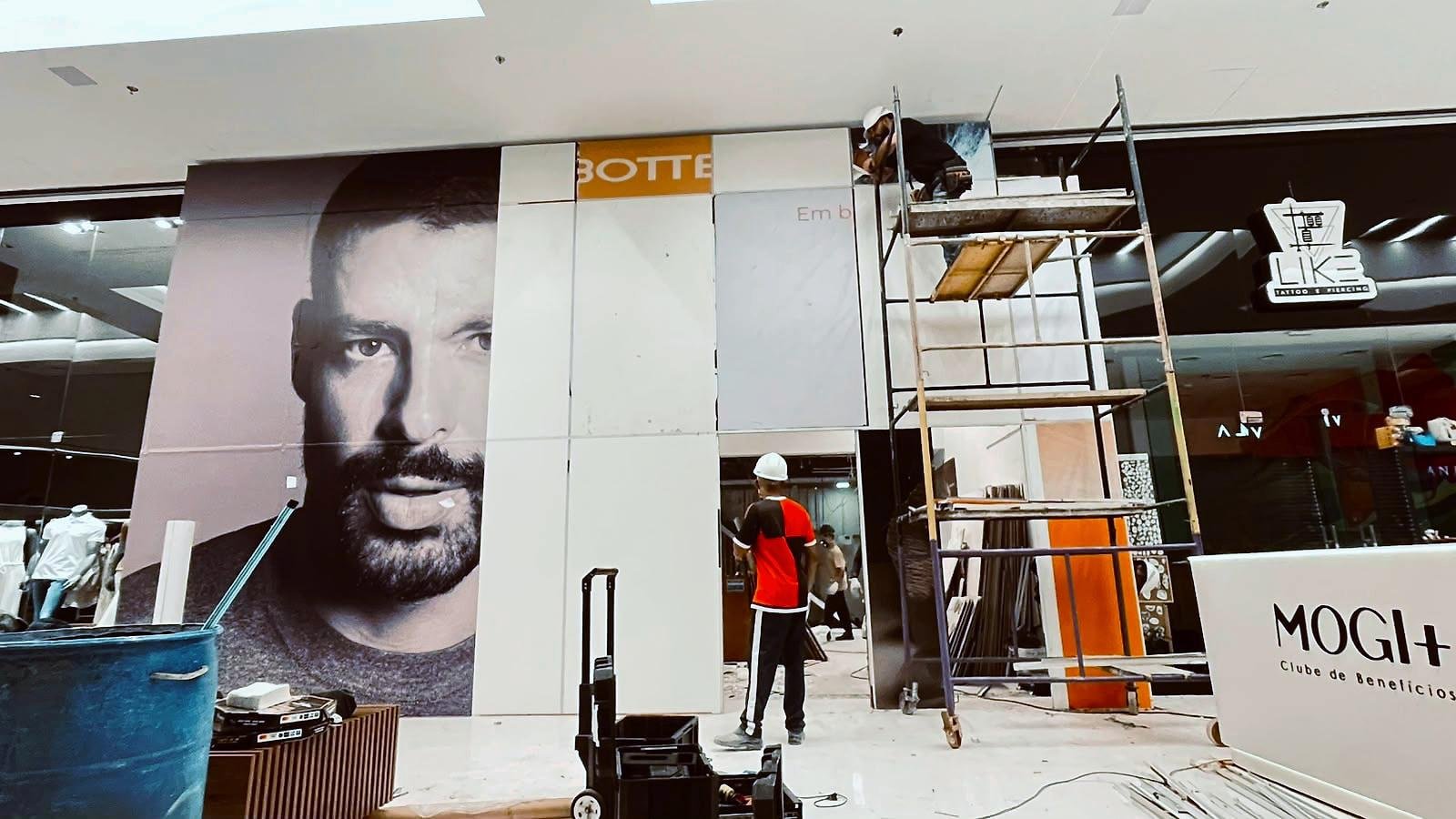 Equipe da Swan aplicando o adesivo da Democrata no tapume, painel por painel