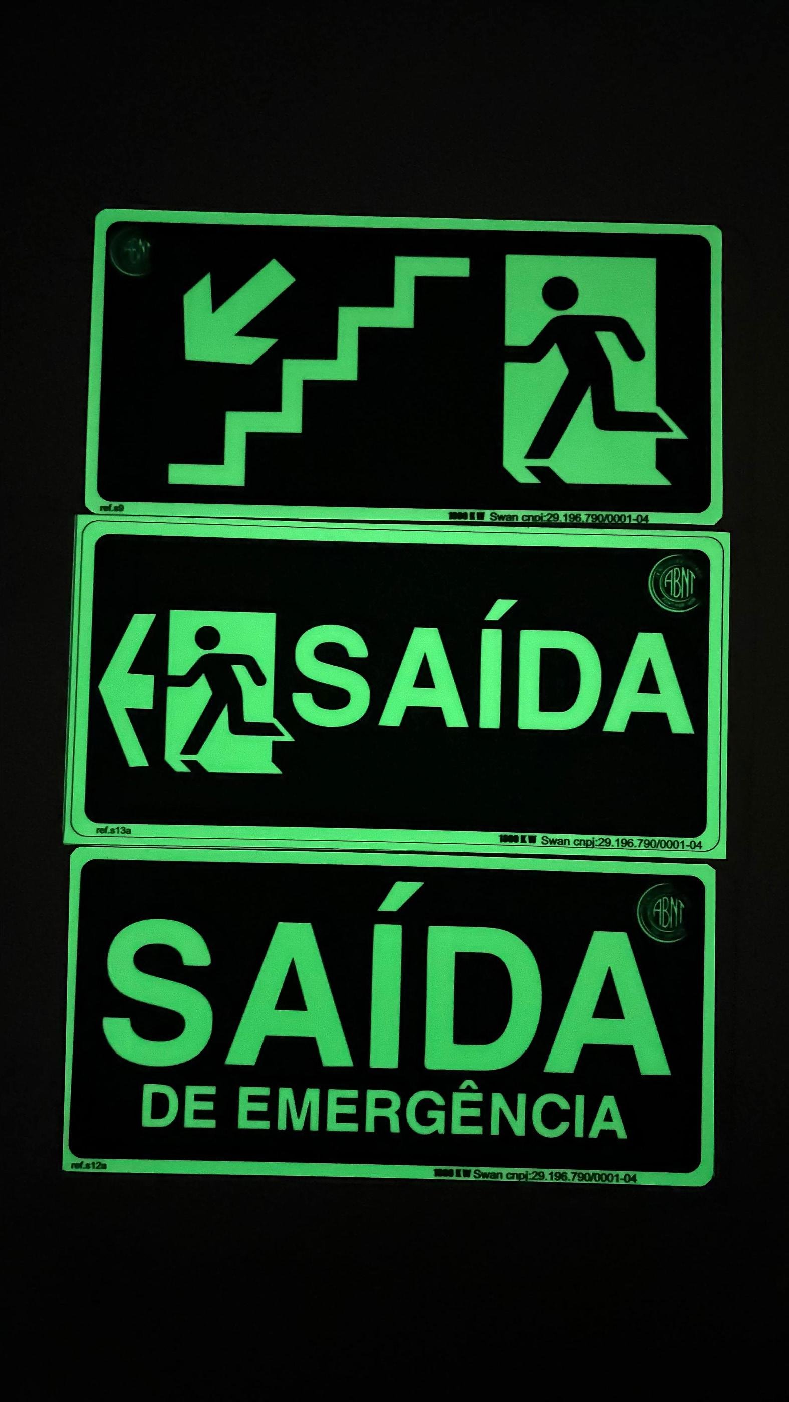 Placas de rota de fuga brilhando verde no escuro: saída e saída de emergência