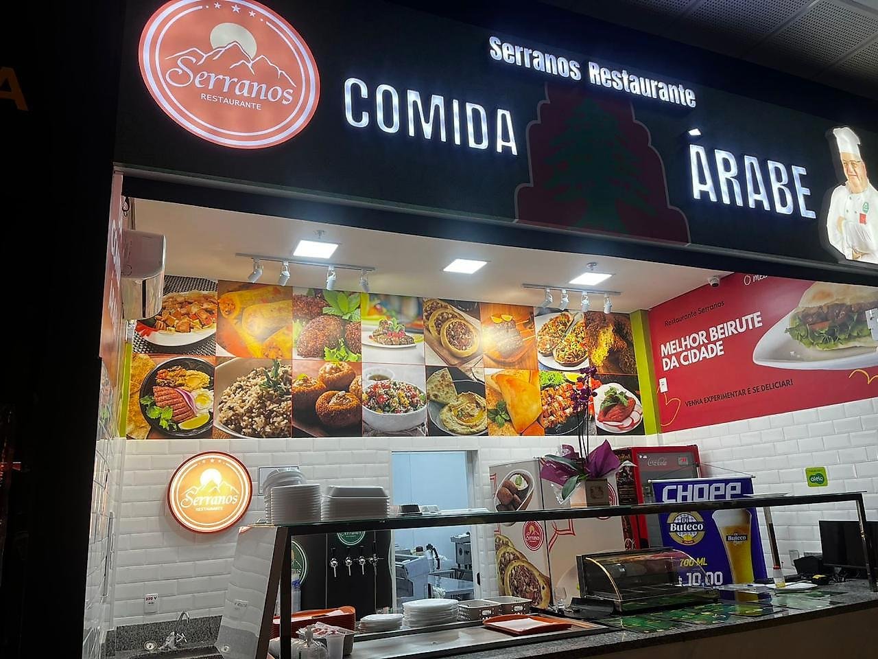 Balcão do Serranos Restaurante, com o painel de fotos dos pratos adesivado